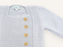 Gros plan sur l'encolure carrée et le plastron en point mousse du gilet bébé Tichat bleu ciel