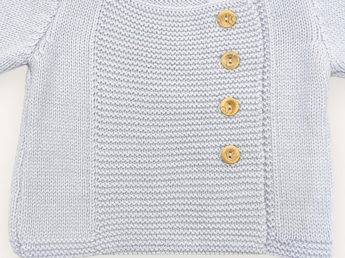 Détail du plastron, des boutons en buis et du bas du tricot du gilet bébé Tichat bleu ciel