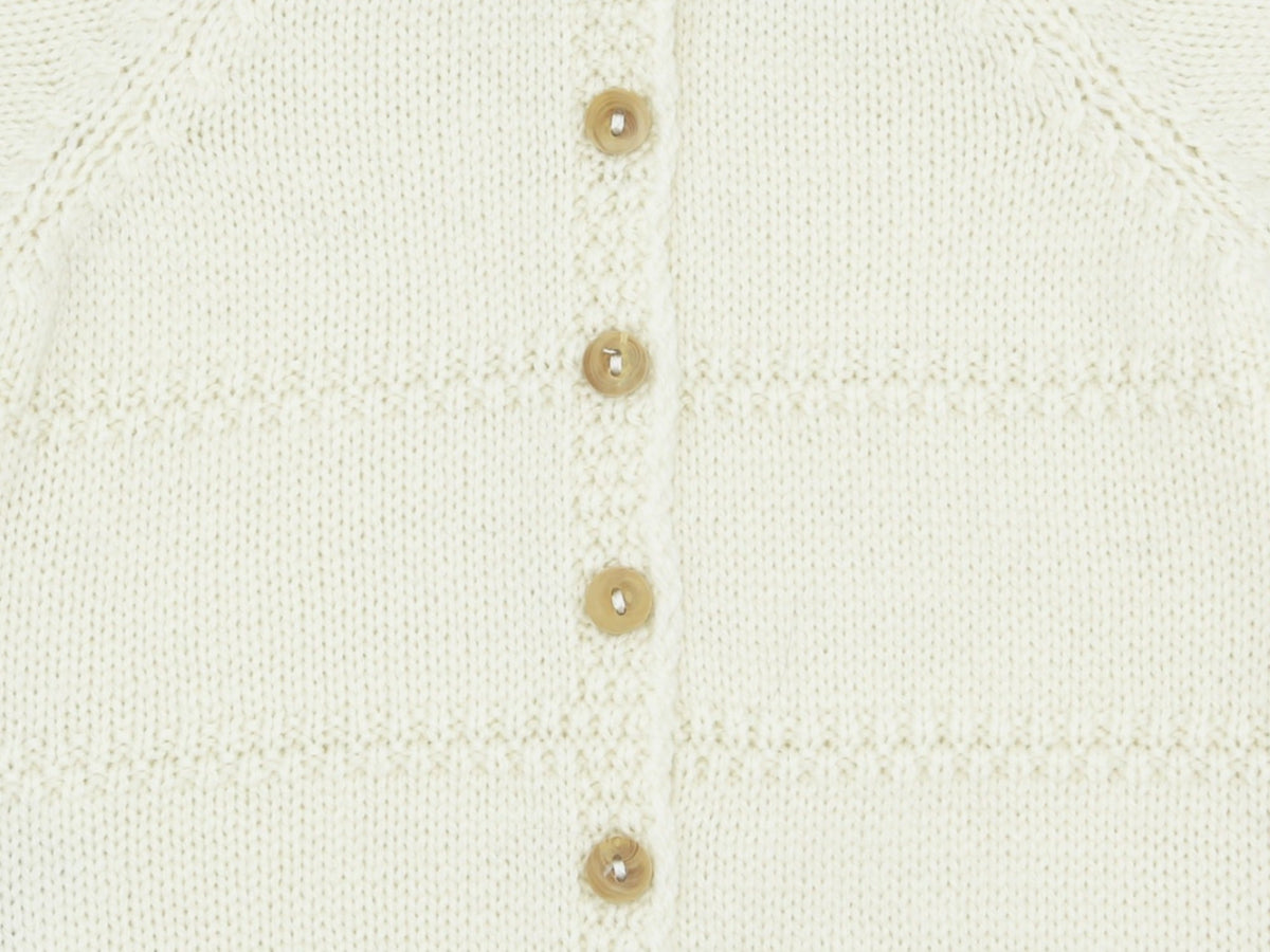 Close-up of the back buttoning, boxwood buttons and alternating jersey and double moss stitch of the ecru Zouzou preemie cardigan