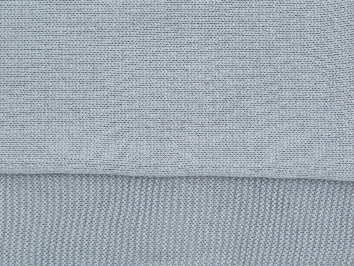 Close-up of the jersey knit and garter stitch border of the blue-grey Tatou baby blanket