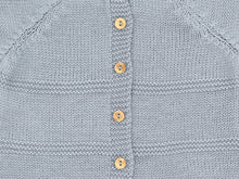 Gros plan sur le boutonnage dos, les boutons en buis et l'alternance de maille jersey et point mousse de la brassière bébé Zazou gris-bleu
