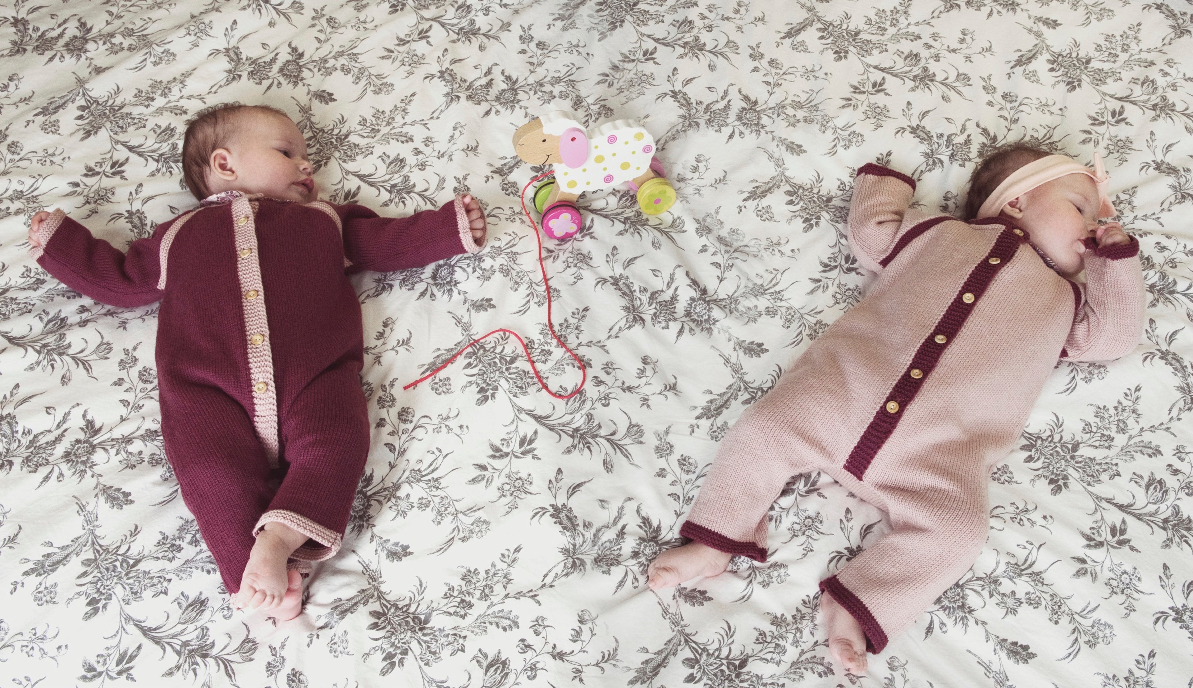 coffret de deux combinaisons bébé fille en laine mérinos rose et prune tricotées en laine mérinos