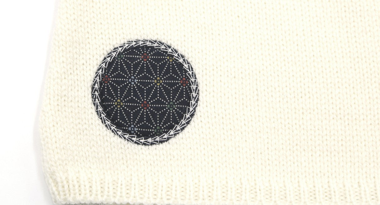 Détail d'un motif en tissu sur un pull bébé en laine mérinos extrafine