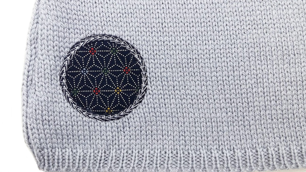 Détail d'un motif en tissu bleu sur une brassière pour prématuré gris bleu en laine mérinos extrafine