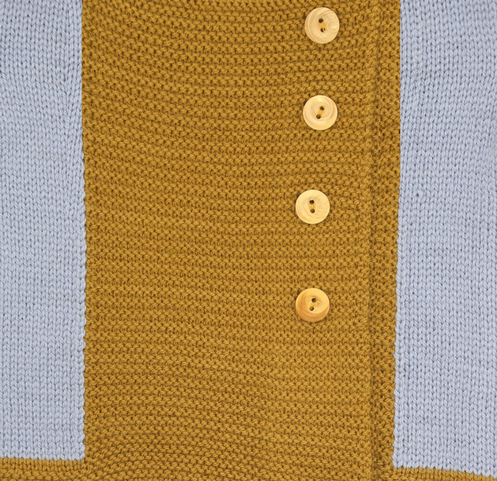Détail du tricot d’un gilet bébé en laine mérinos extrafine