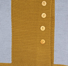 Détail du tricot d’un gilet bébé en laine mérinos extrafine