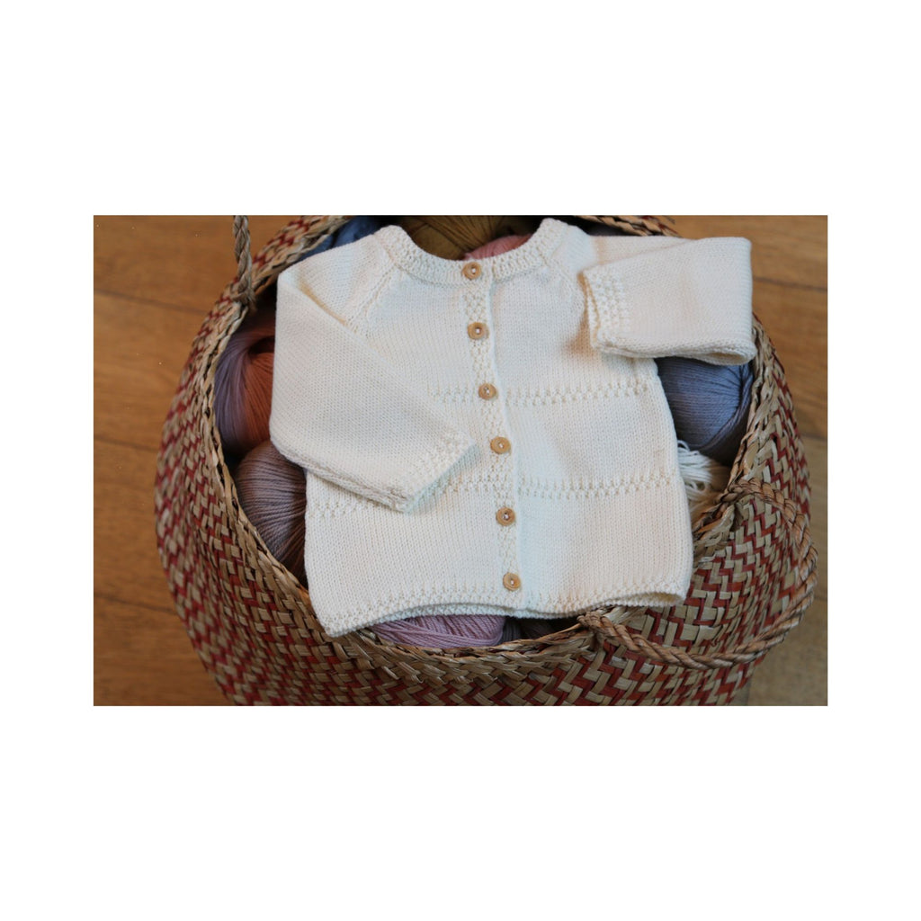 Vue du boutonnage dos d’une brassière bébé en laine mérinos écru